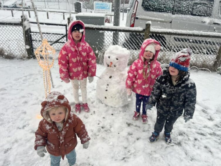 Children build a snowman in Kirriemuir