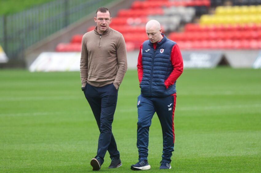 Neill Collins and Mark McKenna walk across the Firhill pitch.