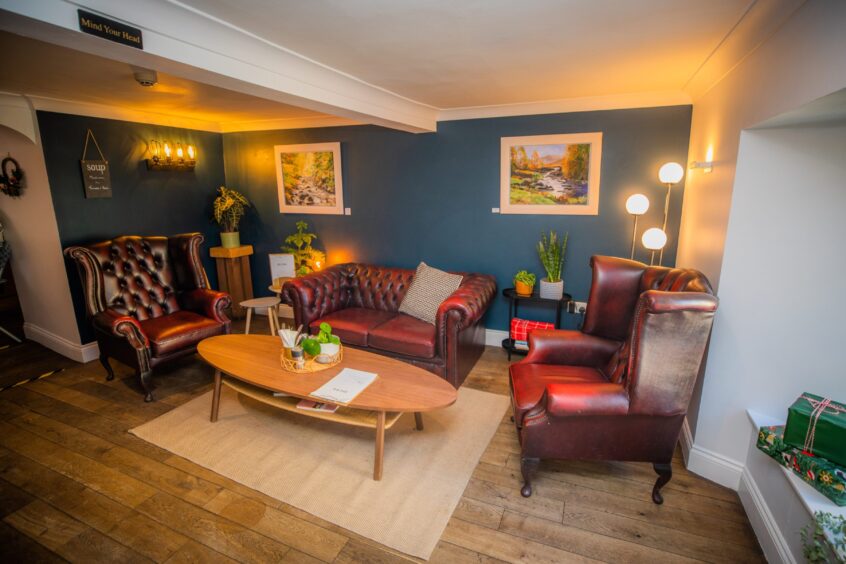 A cosy corner in Fika with red leather seats and coffee tables.