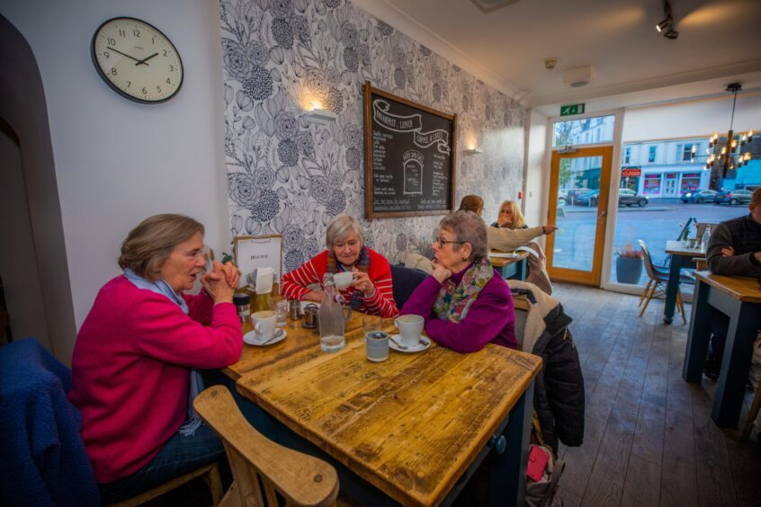 Customers sitting at the tables in Fika enjoying food and drinks.