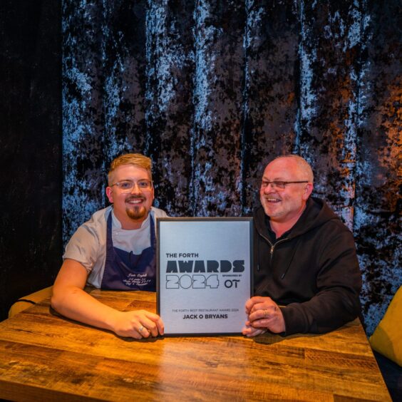 Bryan and Jack Coghill with their latest award, sitting inside their restaurant.