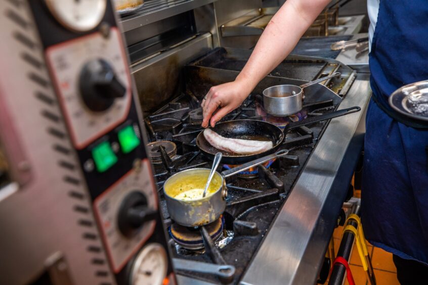 Chef Jack places the monkfish tail in a hot pan.