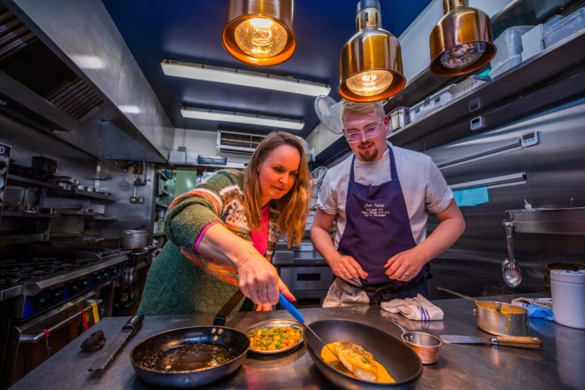 Rachel gently places the monkfish on top of the pale orange thermidor sauce.