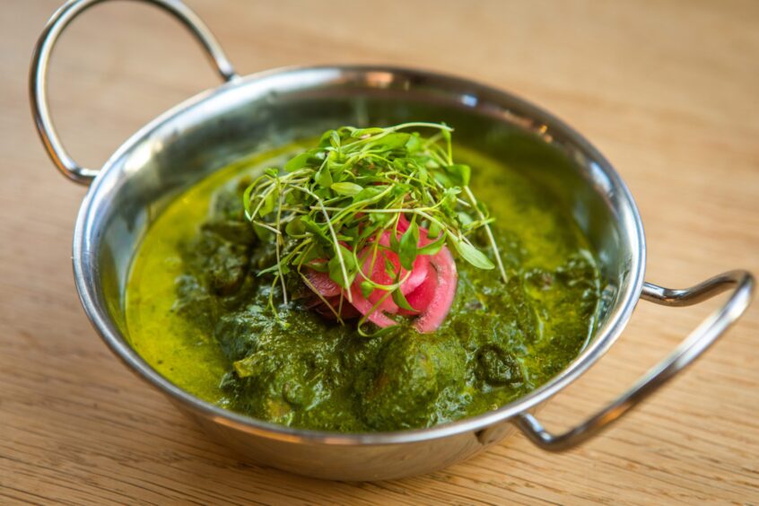 The green palak mushroom with pink pickled onions and microgreens on top.