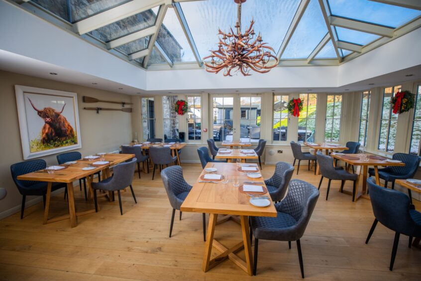 The Orangery restaurant is classy and stylish at The Old Manse of Blair. It has grey seats and pine coloured tables and a large statement ceiling light comprised of many deer antlers.