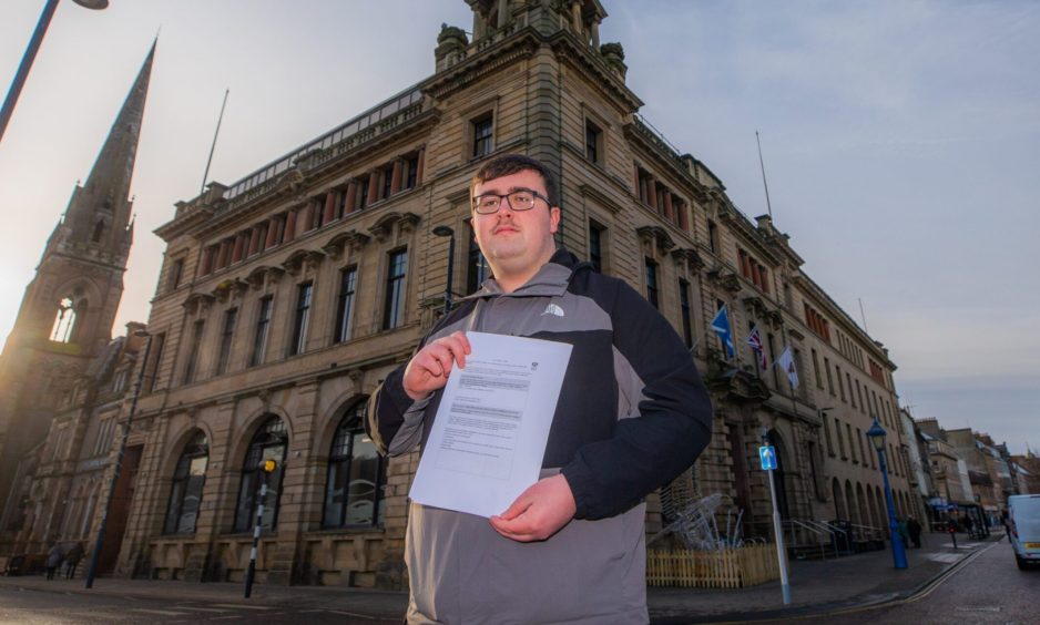 Bobby Brian holds the petition and stands in from of Perth and Kinross Council building.