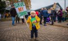 Small boy holding 'save my library' placard