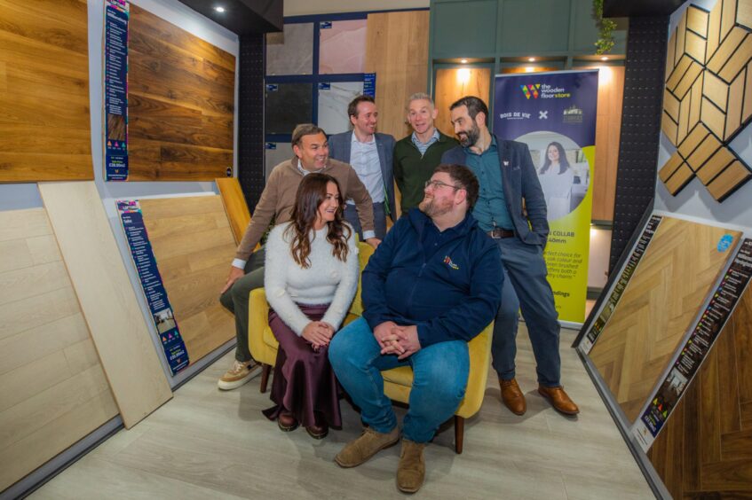 Marie Storrie with group of people surrounded by wooden flooring products