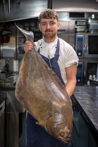 Head chef Adam Kidd holding a massive 12Kg Halibut