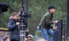 James McAvoy climbs railings to get a vantage point during filming of California Schemin' in the Hilltown. Image: Steve Brown/DC Thomson