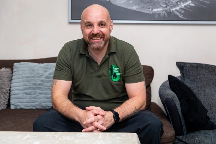 Fife veteran Mick Cairns smiles as he sits on a couch