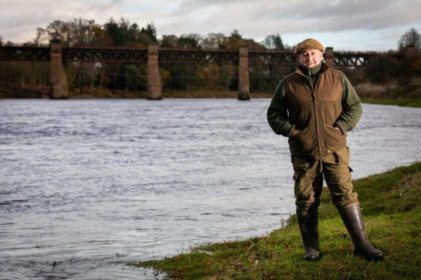 David Godfrey standing beside river