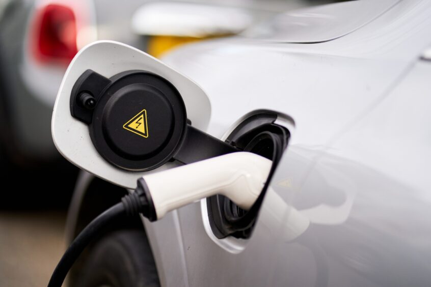 Electric car plugged into an EV charging point. John Walton/PA Wire