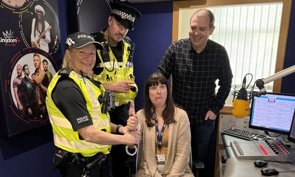 Kingdom FM presenters Vanessa Motion and Dave Connor with police officers during the 'arrest' live on-air.