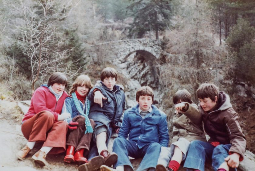 youngsters pose for a pic in woods with a bridge in the background while on a Fintry Clubbie trip to Kinloch Rannoch in 1979 