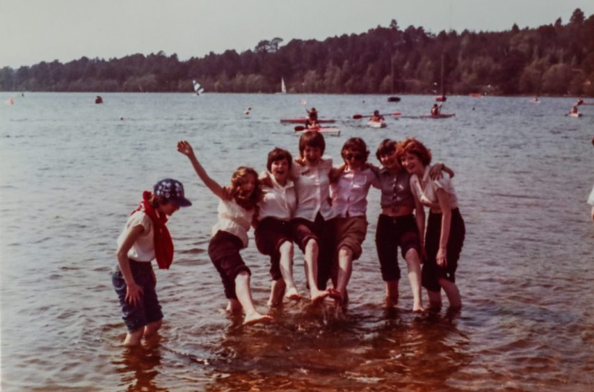 paddling with trousers rolled up to their knees, these youngsters are having a splashing time at Loch Morlich in 1979