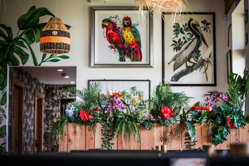 The funky decor at Salty's restaurant with a colourful bird on the wall and bright flowers.