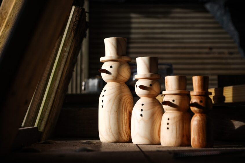 Image shows: cute little wooden snowmen made by the men at St Andrews Men's Shed.