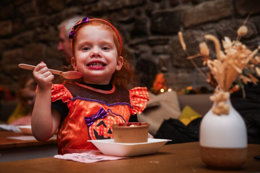 Sweetpea Cafe owner Zoe's daughetr Lily at the crumble pop-up wearing an orange Halloween outfit.