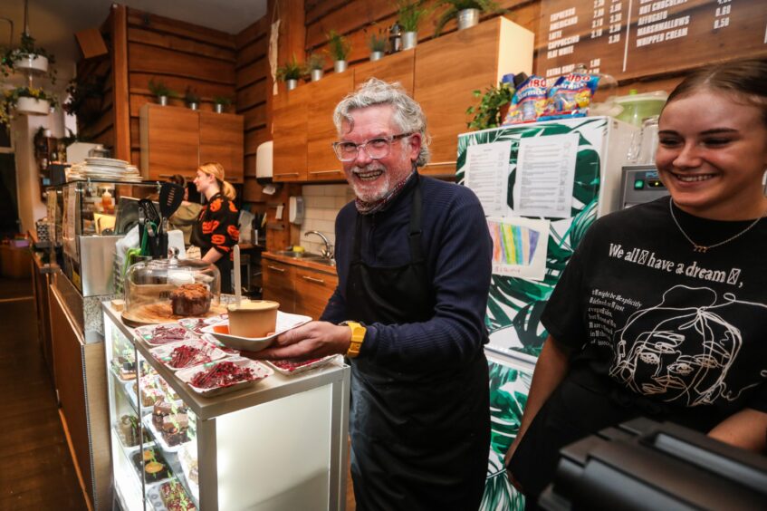 Cafe owner Zoe's dad James Forbes serves crumble at the Sweetpea Cafe pop-up.