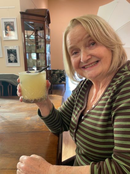 Sheila enjoys her mocktail while waiting for her salad.