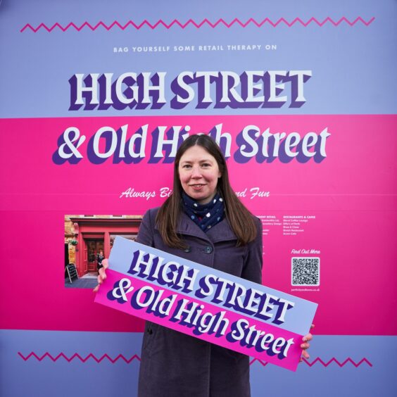 Jenny Christi holding 'High Street and Old High Street' sign