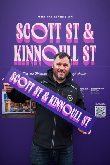 Justin Hay holding 'Scott Street and Kinnoull Street' sign