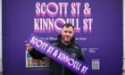 Justin Hy holding sogn for Scotti Street and Kinnoull Street in front of purple billboard