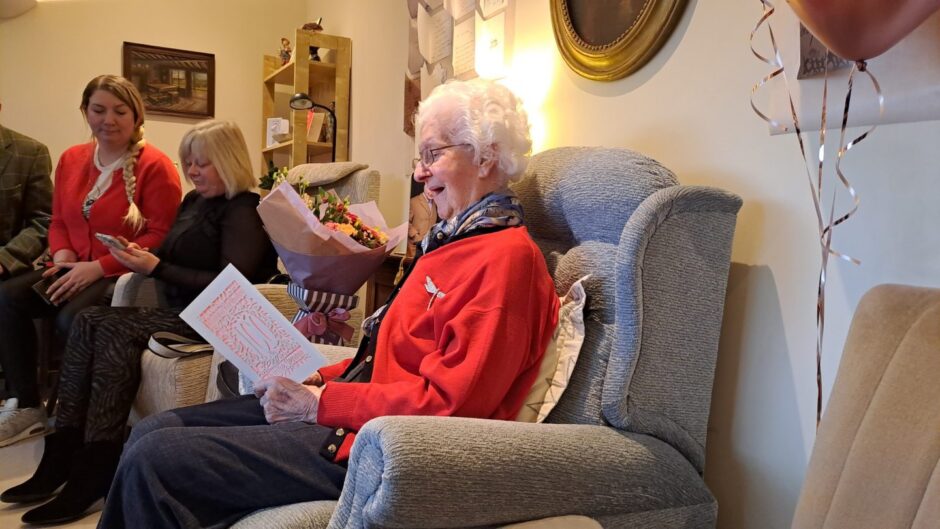 Jenny White smiling as she reads birthday card