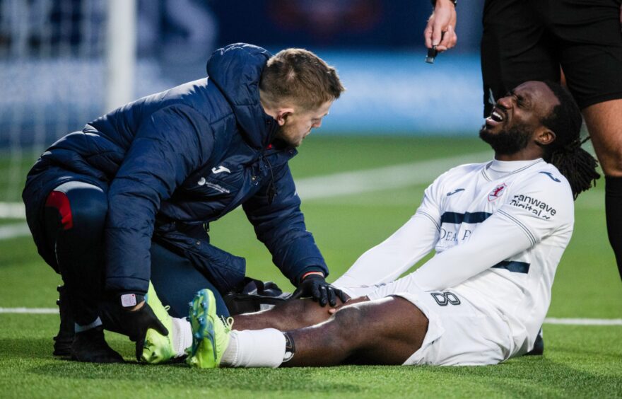 Raith defender Fankaty Dabo receives treatment for an injury.