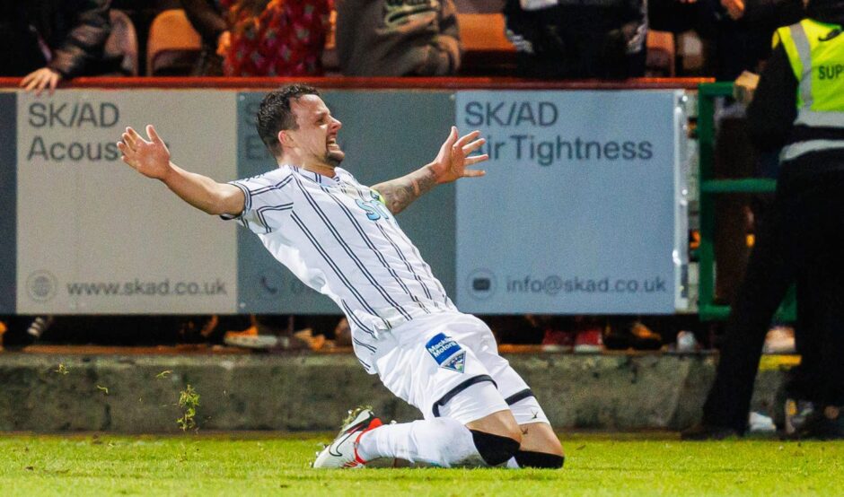 Kyle Benedictus slides on his knees to celebrate his late goal.