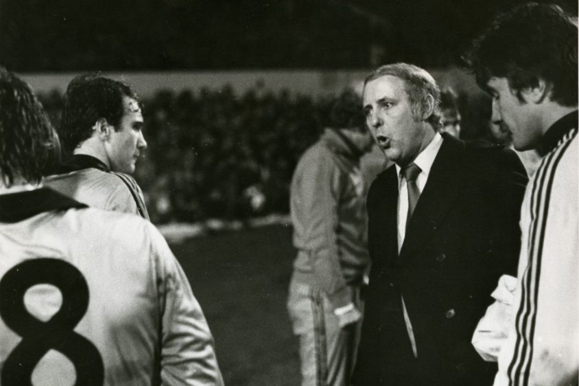 The players listen as Jim McLean gets his message across before extra-time at Hampden.