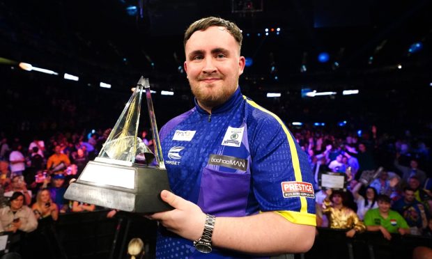 Luke Littler celebrates with the trophy after victory in the final against Luke Humphries during the 2024 BetMGM Premier League play-off at The O2, London. on Thursday May 23, 2024.