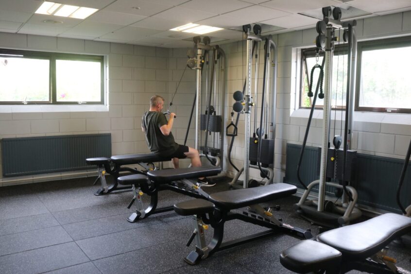 a man sitting on a bench and using gym equipment