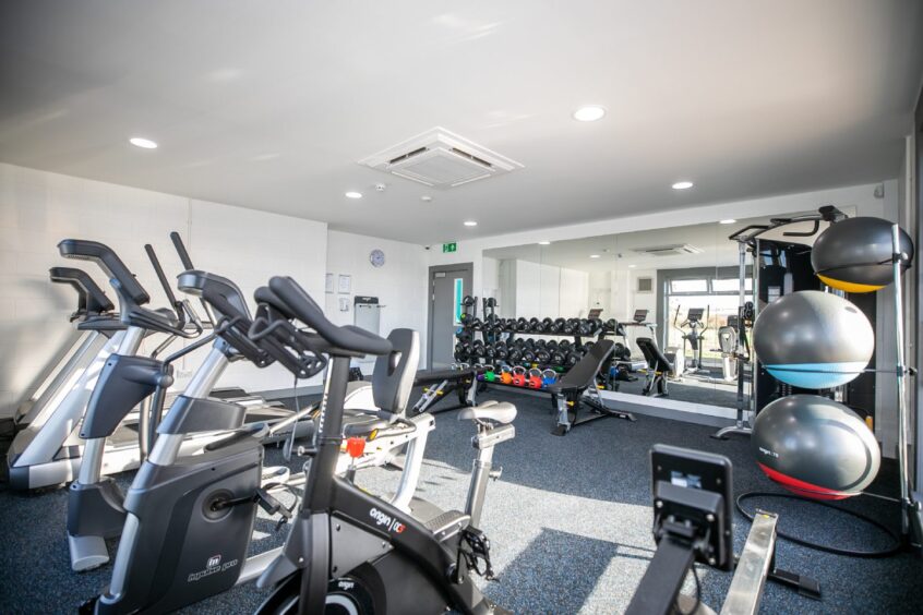 The interior of the gym in the leisure facility at Clayton Caravan Park, with lots of equipment and a mirrored wall