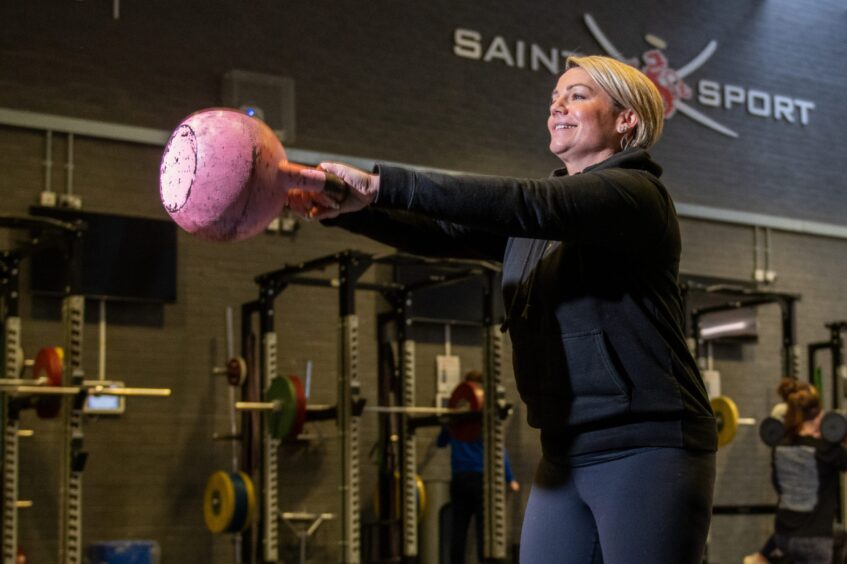 a profile shot of Fiona using a weight inside Saints Sport