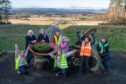 Group of children next to 'living bench' sculpture on bridge over Cross Tay Link Road