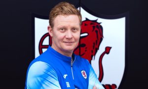 New Rovers boss Barry Robson standing in front of a large Raith badge.