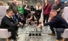Group of people watching man and teenage boy play chess on set made from old Porsche parts at Y Centre in Perth