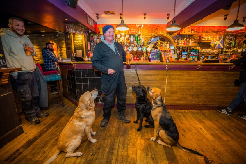 Twa Tams regular James Lackie stands at the bar with his 3 dogs. 