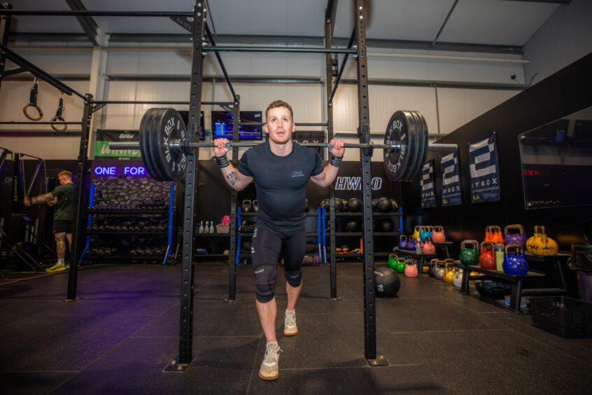 One Performance co-owner and fitness coach Adam Cameron lifting weights