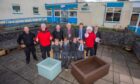 Group of asults and children standing beside wooden planters in Our Lady's Primary School playground
