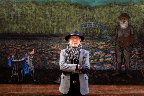 Ian Imrie in front if his new mural, a large painting of Monet's watercolours