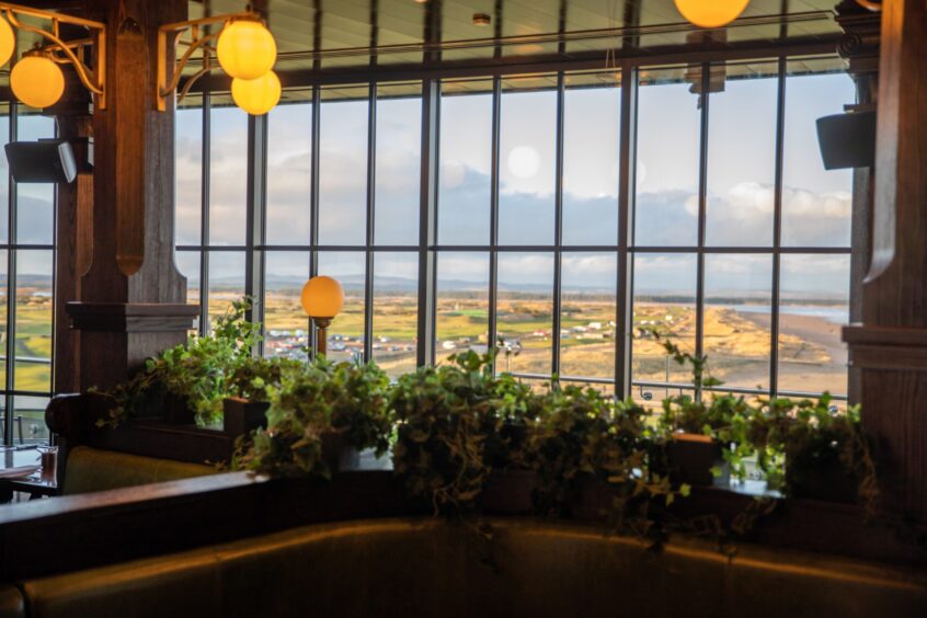 The interior of Restaurant 18 at The Rusacks, St Andrews, showing the views over the golf courses and beach.