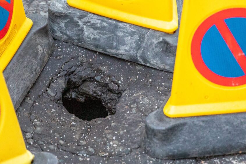 Sinkhole surrounded by traffic cones