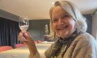 Sheila McConachie smiling and trying the gin at Darnley's gin tour.