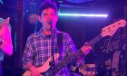 Simeon Chien playing guitar on stage.