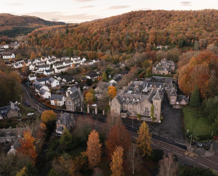 An aerial view of The Birnam Hotel surrounded by autumn trees.