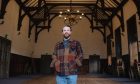 Fraser Potter stands centre in a large room with high ceilings.