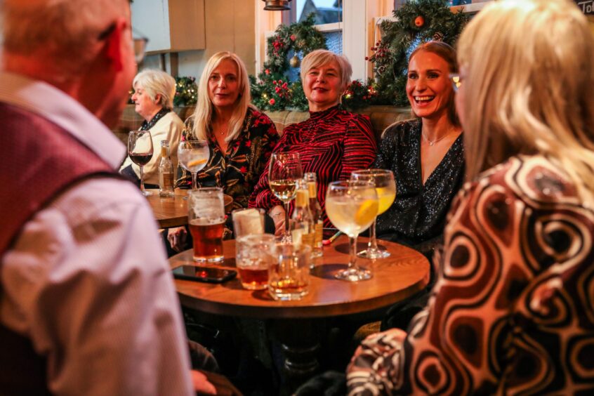 People seated and drinking in The Fisherman's Tavern. 